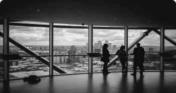 three people closed to windows inside dark room